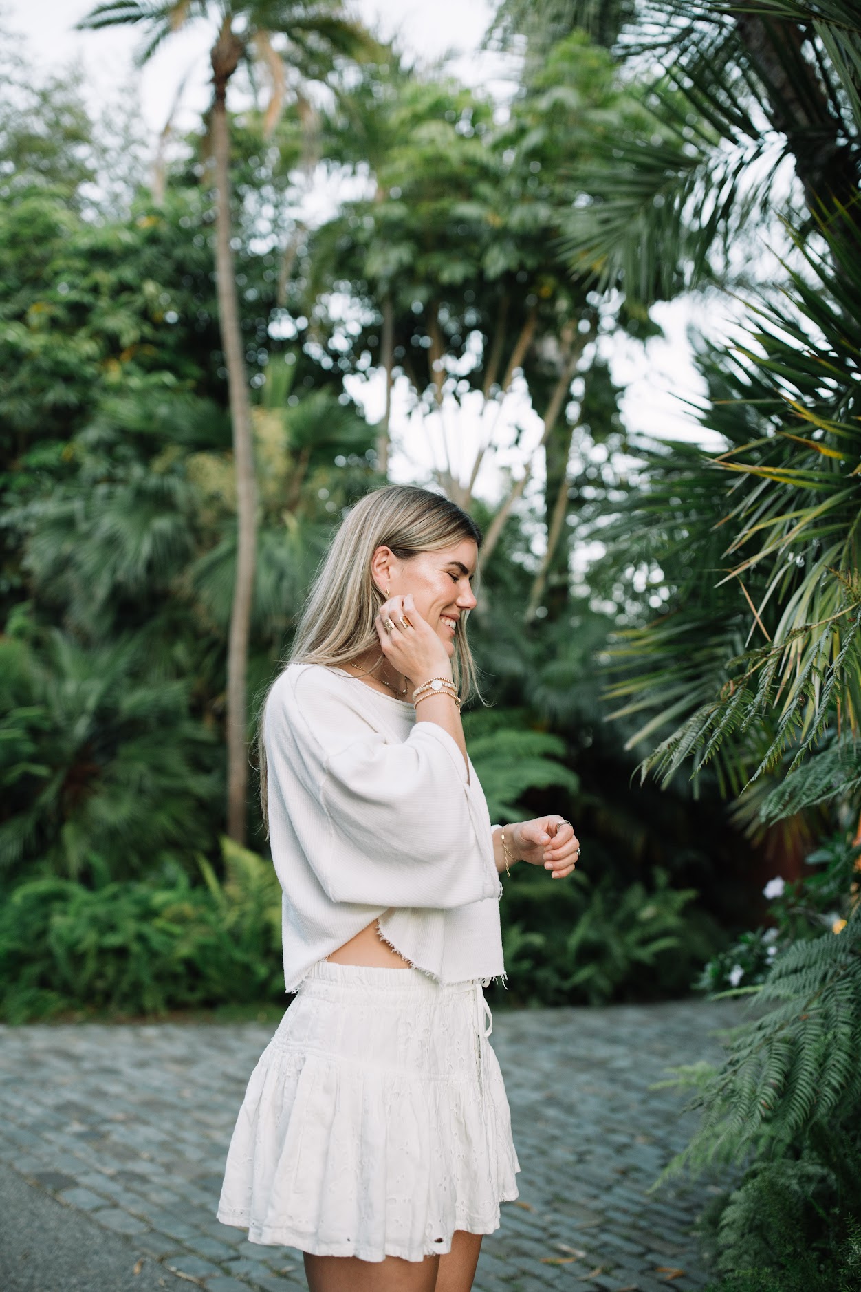 Cambria Joy in white, smiling among the palms