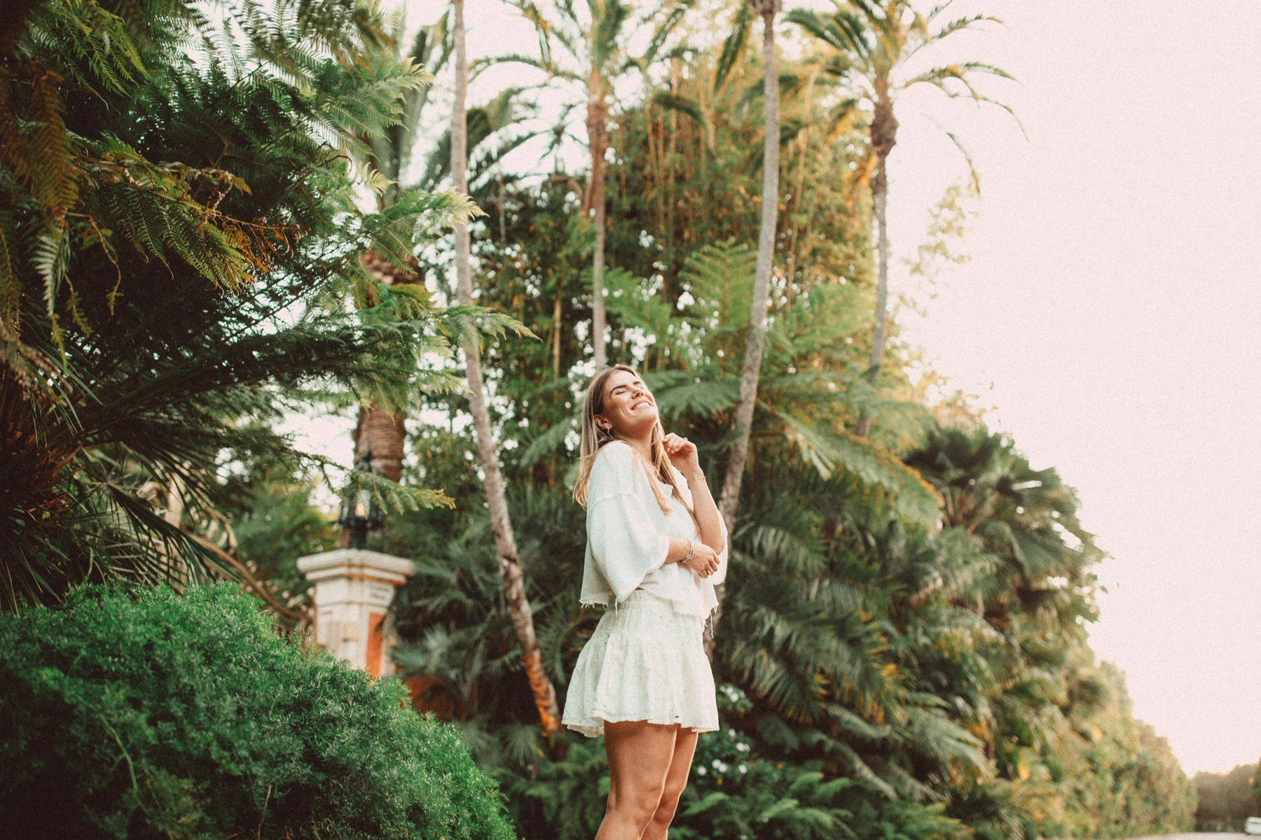 Cambria smiling beneath the palms