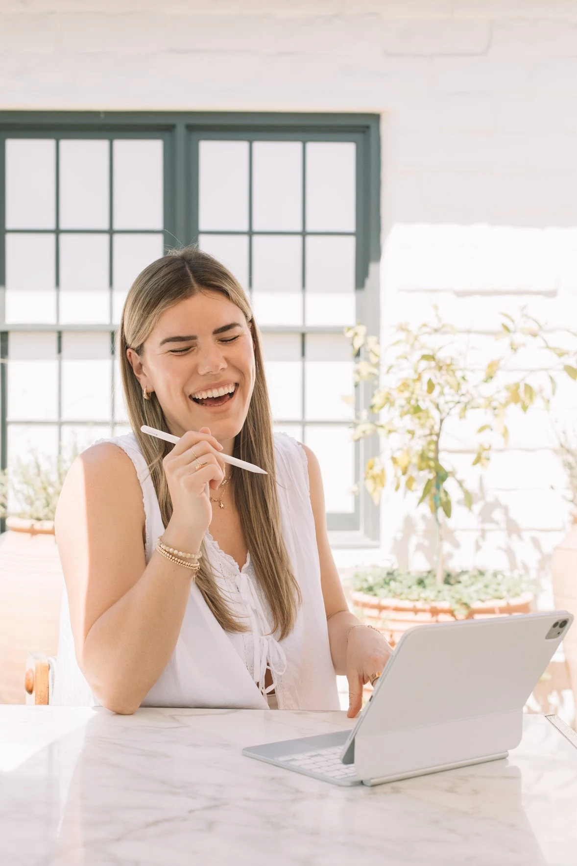 Cambria smiling while working in a sunlit courtyard